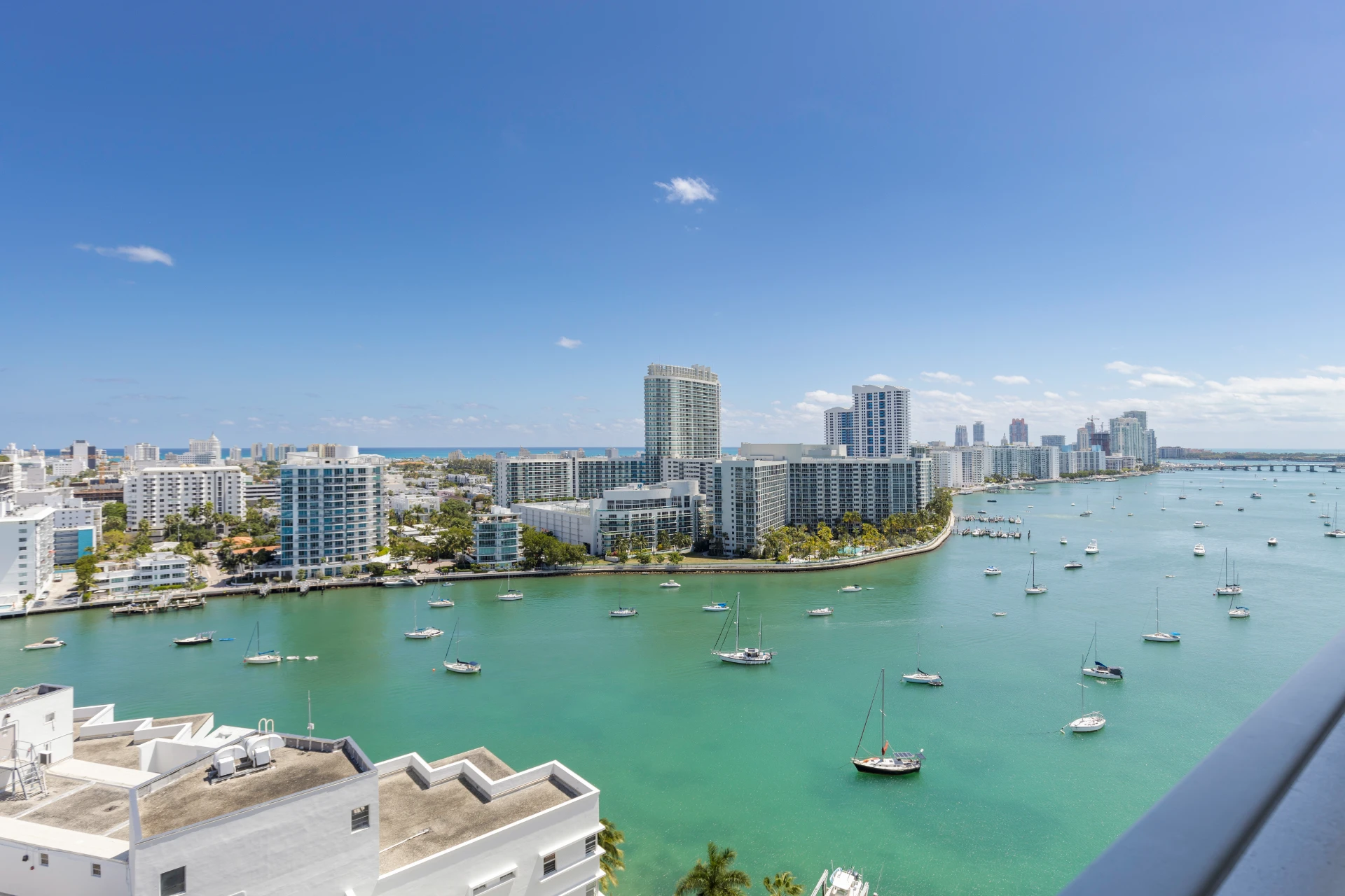 Biscayne Bay with sailboats and Miami Beach waterfront condominiums under a blue sky, South Florida